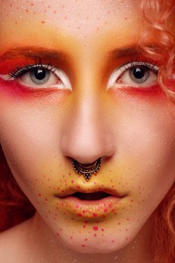 Kızıl saçlı ve parlak makyajlı güzel bir kadın.