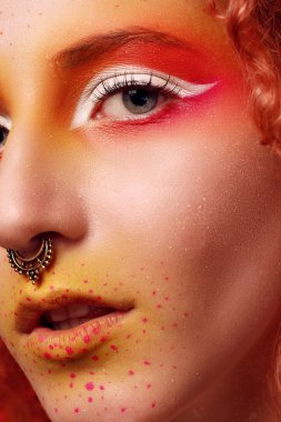 Kızıl saçlı ve parlak makyajlı güzel bir kadın.