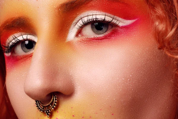 Kızıl saçlı ve parlak makyajlı güzel bir kadın.