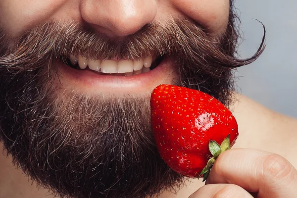 Ritratto ravvicinato giovane che tiene una fragola e sorride — Foto Stock