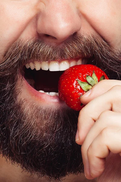 Primer plano retrato joven sosteniendo una fresa y sonriendo — Foto de Stock