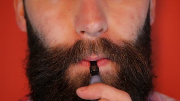 Homem com barba fumando um cigarro eletrônico — Vídeo de Stock