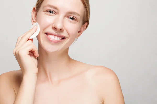 Mujer feliz limpiando su cara con almohadillas de algodón —  Fotos de Stock