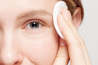 mutlu kadın yüzünü pamuklu ped ile Temizleme