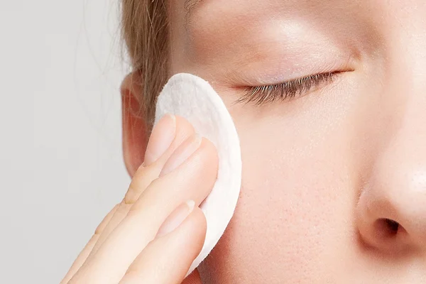 Happy woman cleaning her face with cotton pads — Stock Photo, Image