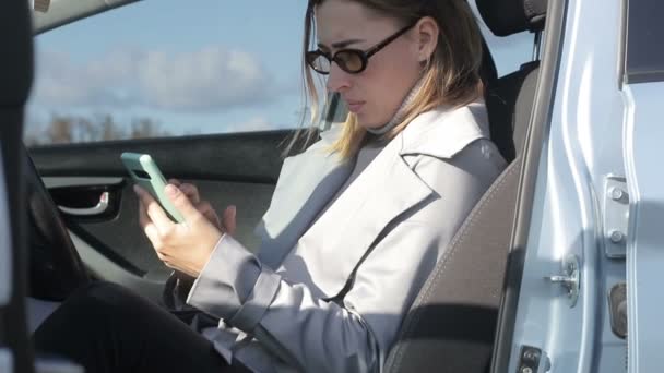 자동차 아름다운 여성은 스마트폰을 전화로 의사소통을 네트워크에서의 — 비디오