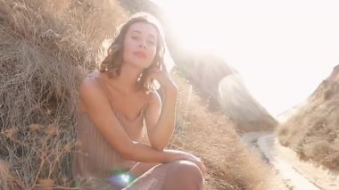 Güneşli bir günde Kanyon 'da durup gülümseyen ve kameraya bakan romantik esmer bir kadının portresi. Sonbaharda gün batımında açık havada mutlu ve güzel bir kadının yüzü. Yavaş çekim 4k