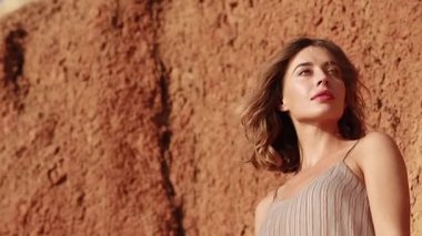 Profile of an attrictive young woman's face outside at sunset with hair blowing in the wind and parallax effect - concepts: sad, lonely, alone, lost, romantic, emotion