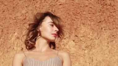 Profile of an attrictive young woman's face outside at sunset with hair blowing in the wind and parallax effect - concepts: sad, lonely, alone, lost, romantic, emotion