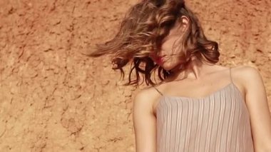 Profile of an attrictive young woman's face outside at sunset with hair blowing in the wind and parallax effect - concepts: sad, lonely, alone, lost, romantic, emotion