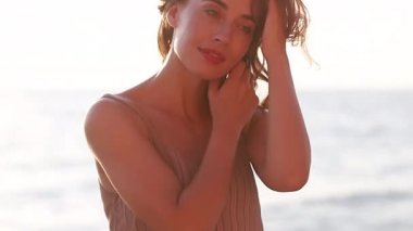 Genç, gülümseyen, çekici bir kız, güzel bir gün batımında deniz kıyısında yürüyor. Gün batımında, tek başına. Kaygısız tropikal rahatlığın, ilham özgürlüğünün, seyahat mutluluğunun, akşam tatilinin tadını çıkarıyorum.