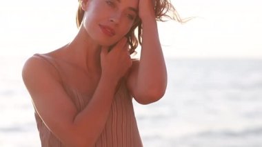 Genç, gülümseyen, çekici bir kız, güzel bir gün batımında deniz kıyısında yürüyor. Gün batımında, tek başına. Kaygısız tropikal rahatlığın, ilham özgürlüğünün, seyahat mutluluğunun, akşam tatilinin tadını çıkarıyorum.