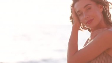 Genç, gülümseyen, çekici bir kız, güzel bir gün batımında deniz kıyısında yürüyor. Gün batımında, tek başına. Kaygısız tropikal rahatlığın, ilham özgürlüğünün, seyahat mutluluğunun, akşam tatilinin tadını çıkarıyorum.