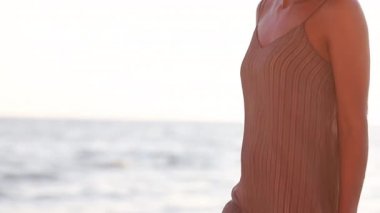 Genç, gülümseyen, çekici bir kız, güzel bir gün batımında deniz kıyısında yürüyor. Gün batımında, tek başına. Kaygısız tropikal rahatlığın, ilham özgürlüğünün, seyahat mutluluğunun, akşam tatilinin tadını çıkarıyorum.
