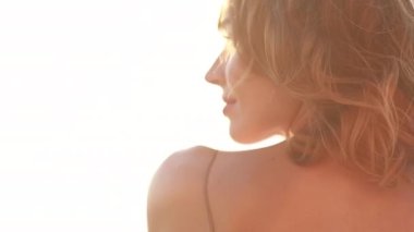 Genç, gülümseyen, çekici bir kız, güzel bir gün batımında deniz kıyısında yürüyor. Gün batımında, tek başına. Kaygısız tropikal rahatlığın, ilham özgürlüğünün, seyahat mutluluğunun, akşam tatilinin tadını çıkarıyorum.