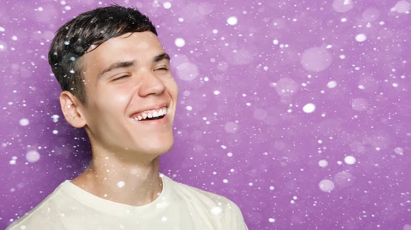 snow, winter, christmas, people, beauty concept - Indoor shot of handsome guy with positive expression, stands against purple background, copy space. People and emotions. smile.16:9 panoramic format.