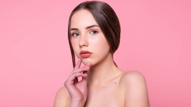 Çekici, neşeli, modaya uygun, çekici, tapılası, çıplak, modern makyajlı, mükemmel, ideal ciltli, pembe arka planda izole bir kız portresi. 16: 9 panoramik biçimi.