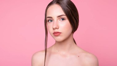 Çekici, neşeli, modaya uygun, çekici, tapılası, çıplak, modern makyajlı, mükemmel, ideal ciltli, pembe arka planda izole bir kız portresi. 16: 9 panoramik biçimi.