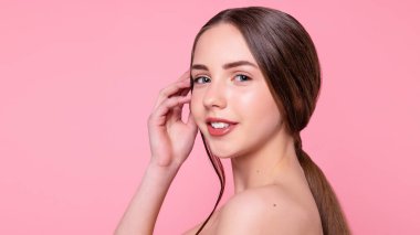 Çekici, neşeli, modaya uygun, çekici, tapılası, çıplak, modern makyajlı, mükemmel, ideal ciltli, pembe arka planda izole bir kız portresi. 16: 9 panoramik biçimi.
