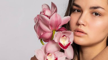 Gri arka planda stüdyoda poz veren kahverengi ceketli baştan çıkarıcı sarışın kadın. Pastel gündelik bahar kıyafetleri içinde zarif bir model. Sağlıklı ciltli ve dallı güzel bir kız. 16: 9 panoramik biçimi.