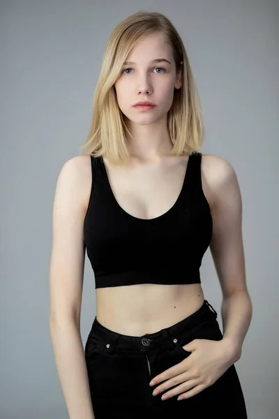 Portret Van Een Casual Blonde Vrouw Zwart Topje Jeans Grijze — Stockfoto
