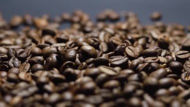 Kavrulmuş kahve çekirdeği. Kokulu kahve çekirdekleri kameranın etrafında yavaşça kayıyor. Yavaş Çekim Tüm Kavrulmuş Kahve Fasulyelerinin Kapanışı.