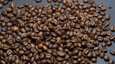 Kavrulmuş kahve çekirdeği. Kokulu kahve çekirdekleri kameranın etrafında yavaşça kayıyor. Yavaş Çekim Tüm Kavrulmuş Kahve Fasulyelerinin Kapanışı.