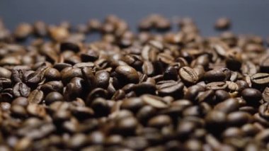 Kavrulmuş kahve çekirdeği. Kokulu kahve çekirdekleri kameranın etrafında yavaşça kayıyor. Yavaş Çekim Tüm Kavrulmuş Kahve Fasulyelerinin Kapanışı.