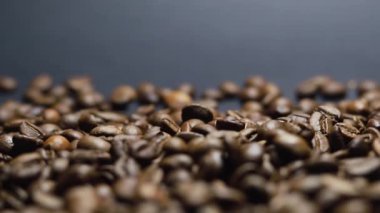 Kavrulmuş kahve çekirdeği. Kokulu kahve çekirdekleri kameranın etrafında yavaşça kayıyor. Yavaş Çekim Tüm Kavrulmuş Kahve Fasulyelerinin Kapanışı.
