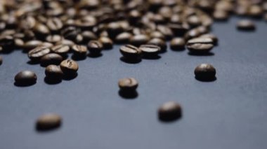 Kavrulmuş kahve çekirdeği. Kokulu kahve çekirdekleri kameranın etrafında yavaşça kayıyor. Yavaş Çekim Tüm Kavrulmuş Kahve Fasulyelerinin Kapanışı.