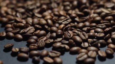 Kavrulmuş kahve çekirdeği. Kokulu kahve çekirdekleri kameranın etrafında yavaşça kayıyor. Yavaş Çekim Tüm Kavrulmuş Kahve Fasulyelerinin Kapanışı.