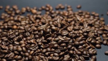 Kavrulmuş kahve çekirdeği. Kokulu kahve çekirdekleri kameranın etrafında yavaşça kayıyor. Yavaş Çekim Tüm Kavrulmuş Kahve Fasulyelerinin Kapanışı.