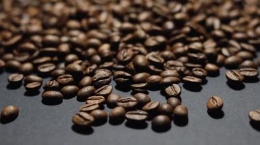 Kavrulmuş kahve çekirdeği. Kokulu kahve çekirdekleri kameranın etrafında yavaşça kayıyor. Yavaş Çekim Tüm Kavrulmuş Kahve Fasulyelerinin Kapanışı.
