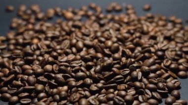Kavrulmuş kahve çekirdeği. Kokulu kahve çekirdekleri kameranın etrafında yavaşça kayıyor. Yavaş Çekim Tüm Kavrulmuş Kahve Fasulyelerinin Kapanışı.