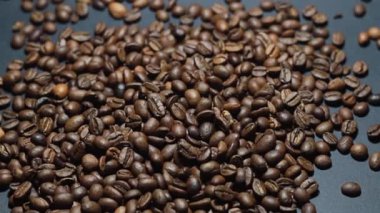 Kavrulmuş kahve çekirdeği. Kokulu kahve çekirdekleri kameranın etrafında yavaşça kayıyor. Yavaş Çekim Tüm Kavrulmuş Kahve Fasulyelerinin Kapanışı.