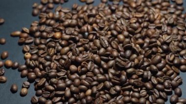 Kavrulmuş kahve çekirdeği. Kokulu kahve çekirdekleri kameranın etrafında yavaşça kayıyor. Yavaş Çekim Tüm Kavrulmuş Kahve Fasulyelerinin Kapanışı.