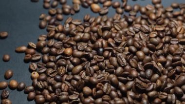 Kavrulmuş kahve çekirdeği. Kokulu kahve çekirdekleri kameranın etrafında yavaşça kayıyor. Yavaş Çekim Tüm Kavrulmuş Kahve Fasulyelerinin Kapanışı.