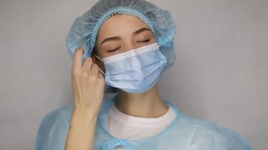 Korunma maskeli kadın doktor hastaları hastaneye yatırdıktan sonra yorgun, bitkin ve hayal kırıklığına uğramış görünüyor. Tıbbi personel salgını konsepti