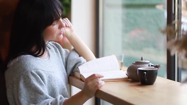 Красивая Юная Леди Читает Книгу Кафе Наслаждаясь Современной Литературой Одиночеством — стоковое видео