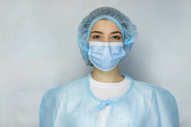 Bulaşıcı hastalıklara karşı koruma, koronavirüs. Hijyenik yüz cerrahi maskesi takan kadın doktor. Panorama panorama tıbbi personel önleyici ekipman. Stüdyo fotoğrafı, hastalık