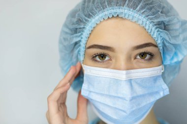 Koronavirüslü koruyucu tıbbi maskeli bir kadının portresi pandemik hakkında endişeli endişeli, endişeli bir kadın covid-19 Corona salgınından korunmak için yüz maskesi takıyor.