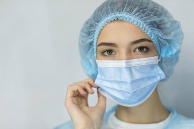 Koronavirüslü koruyucu tıbbi maskeli bir kadının portresi, pandemik bir hastalıktan endişe duyuyor, endişeli bir kadın, covid-19 Corona salgınından korunmak için yüz maskesi takıyor.,