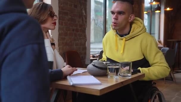 Szczęśliwy Młody Niepełnosprawny Mężczyzna Wózku Inwalidzkim Kawiarni Komunikuje Się Przyjaciółmi — Wideo stockowe
