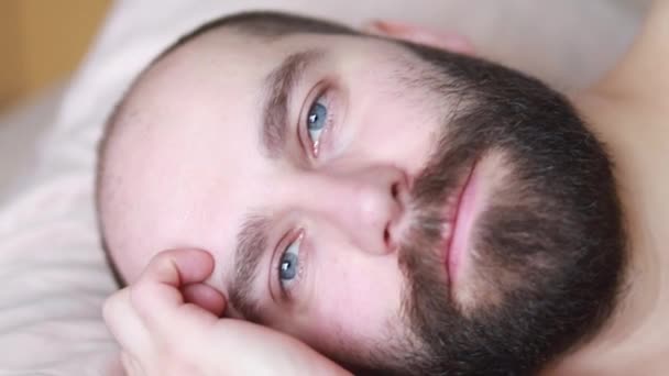 Yakışıklı Gülümseyen Esmer Adamın Yakın Görüntüsü Gözlerini Açıyor Sabah Yatakta — Stok video