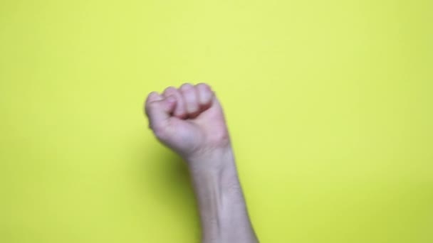 Сжатая Кулачная Рука Поднимается Воздух Желтом Фоне Знак Протеста Сопротивляйтесь — стоковое видео