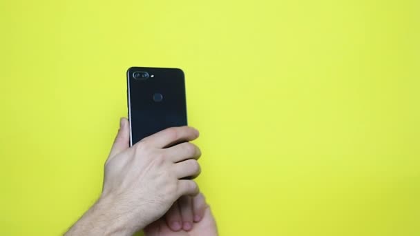 Mãos Masculinas Usando Smaprtphone Sobre Fundo Amarelo — Vídeo de Stock