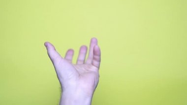 Sarı arka planda uzanmış erkek el, 4k görüntü.