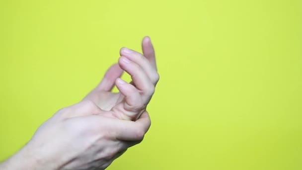 Close Homem Tenta Aliviar Dor Sua Mão Fundo Amarelo Imagens — Vídeo de Stock