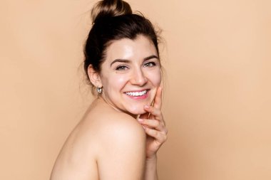 Güzellik, insanlar, cilt bakımı ve sağlık konsepti - genç kadın yüzü ve elleri bej arka planda, gülen mutlu, mutlu, genç, kızıl saçlı bir kadının portresi
