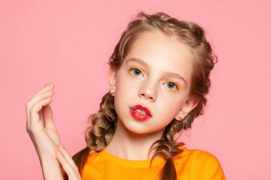 Güzel görünümlü, sevimli, sevimli, neşeli, neşeli, zeki kız yeni bir fikir üretiyor. Fotokopi alanı, izole edilmiş pembe pastel arka plan fantezisi kuruyor.